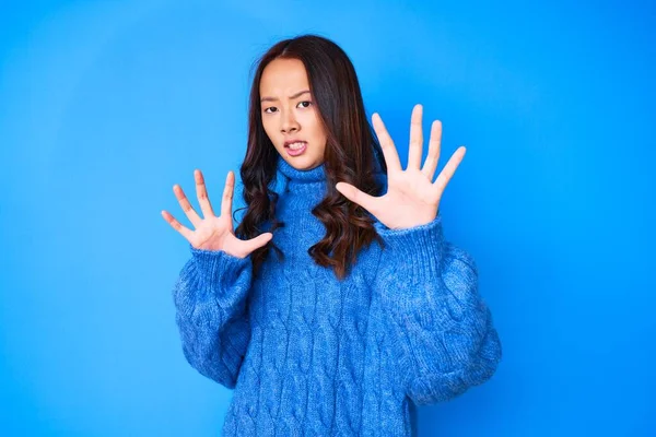 若い美しい中国の少女は カジュアルな冬のセーターを着て恐怖表現を恐れて手でジェスチャーを停止し ショックで叫んで恐れている パニックの概念 — ストック写真