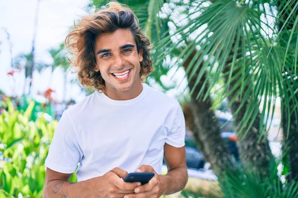 Joven Hombre Hispano Sonriendo Feliz Usando Smartphone Calle Ciudad —  Fotos de Stock