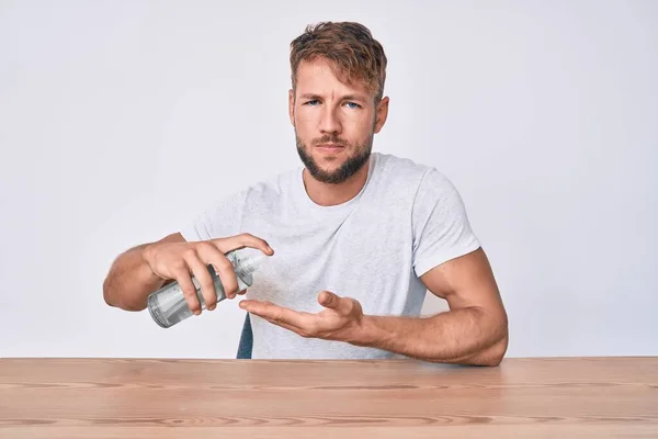 Jonge Blanke Man Met Behulp Van Hand Ontsmettingsgel Zitten Tafel — Stockfoto