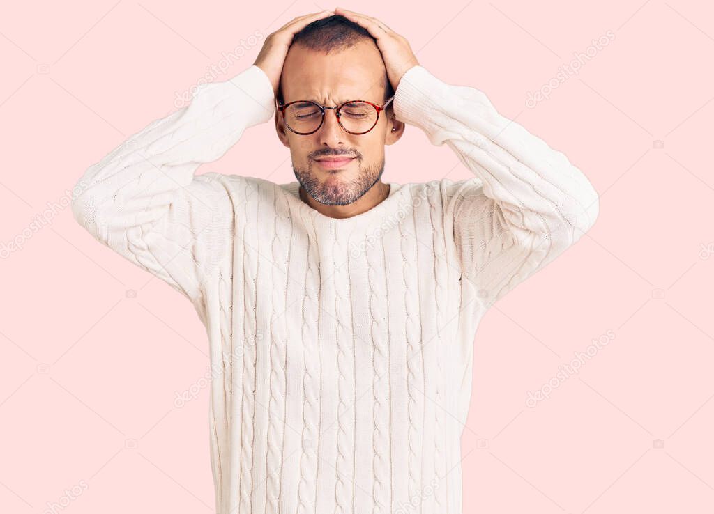 Young handsome man wearing casual clothes and glasses suffering from headache desperate and stressed because pain and migraine. hands on head. 