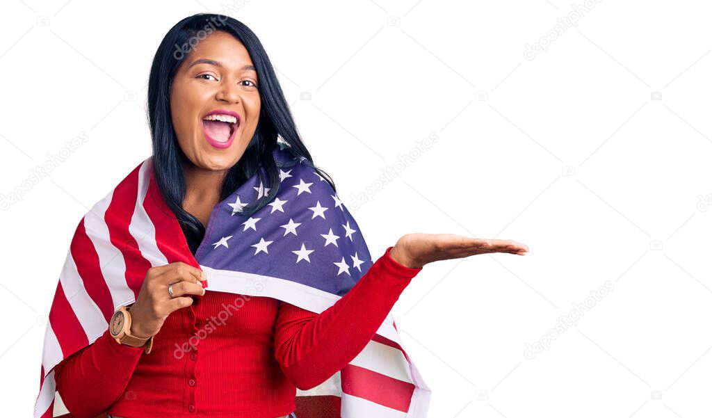 Hispanic woman with long hair holding united states flag celebrating victory with happy smile and winner expression with raised hands 