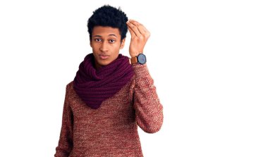 Genç Afro-Amerikan adam günlük kışlık süveter ve eşarp giyiyor. İtalyan jesti yapıyor. Elleri ve parmakları kendinden emin. 