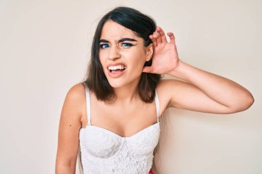 Esmer genç kız kulağına fısıldayarak zarif bir şekilde poz veriyor. Dedikoduları ve dedikoduları dinliyor. Sağırlık kavramı. 