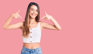 Kolsuz tişört giyen genç ve güzel bir kız. Kendine güvenen, gülümseyen, kendini gururlu ve mutlu gösteren bir kız.. 