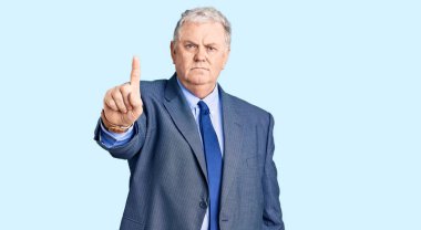 Yaşlı, gri saçlı, iş ceketi giyen, parmağını kaldırmış, kızgın bir ifade takınan, hiç hareket göstermeyen bir adam. 