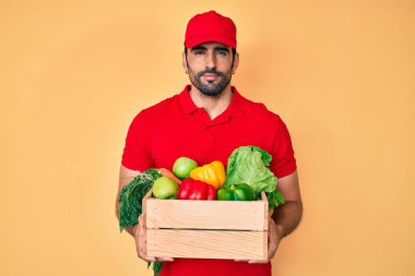 Yakışıklı, sakallı, üniformalı, elinde teslimat yemeği tutan, yüzünde ciddi bir ifadeyle rahatlamış bir İspanyol. Basit ve doğal bir şekilde kameraya bakıyorsun.. 