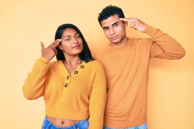 Güzel Latin genç çift, günlük kıyafetlerini giyip silah gibi el ve parmaklarını birbirine doğrultarak ateş ederek ve öldürerek intihar ediyorlar.. 