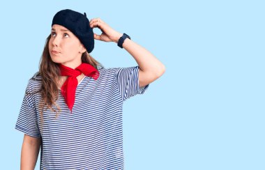 Fransız beresi takan ve çizgili tişört giyen genç, güzel bir sarışın kadın. Kafasını karıştırıyor ve soru soruyor. Şüpheyle kararsız, kafa kafaya düşünerek. Düşünceli kavram. 