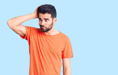 Sıradan tişörtler giyen sakallı yakışıklı genç bir adam kafası karışıyor ve soru soruyor. Şüpheyle kararsız, kafa kafaya düşünerek. Düşünceli kavram. 