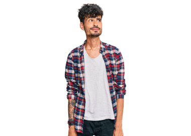 Gündelik kıyafetler giyen genç İspanyol adam gülümseyip yan tarafa bakıyor ve düşünüyor.. 