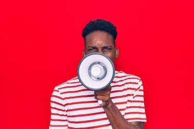 Genç Afrikalı adam kızgın bir şekilde megafondan bağırıyor.
