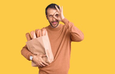 Elinde ekmek torbası olan yakışıklı genç adam gülümsüyor. Mutluluktan gülümsüyor. 