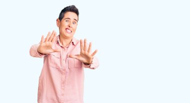 Kısa saçlı, gündelik giysiler giyen, korku ifadesinden korkan ve dehşete düşmüş genç bir kadın. El kol hareketi yapmayı kes, şok içinde bağır. panik konsepti. 