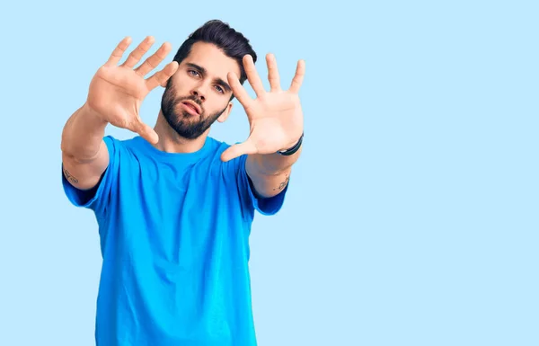 Sakallı Günlük Tişörtlü Parmaklarıyla Çerçeve Yapan Yakışıklı Bir Genç Adam — Stok fotoğraf