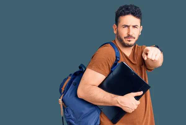 Joven Hombre Hispano Usando Mochila Estudiante Sosteniendo Aglutinante Apuntando Con —  Fotos de Stock