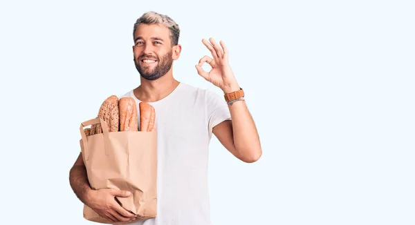 Νέος Όμορφος Ξανθός Άνδρας Κρατώντας Χάρτινη Τσάντα Ψωμί Κάνει Υπογράψει — Φωτογραφία Αρχείου
