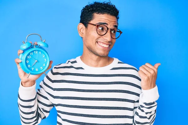 Junge Gut Aussehende Hispanische Mann Mit Wecker Zeigt Daumen Zur — Stockfoto