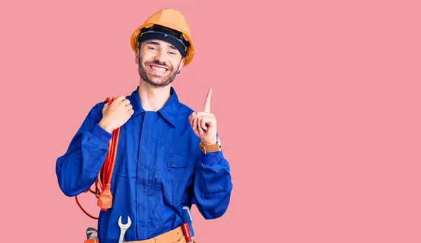 Jovem Hispânico Vestindo Uniforme Eletricista Segurando Cabo Surpreso Com Uma — Fotografia de Stock