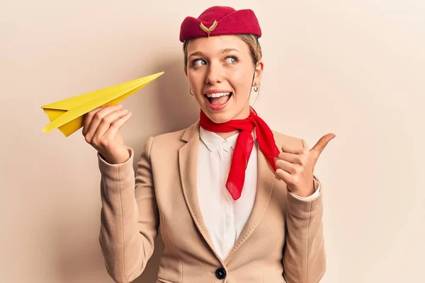 Joven Chica Rubia Hermosa Usando Azafata Uniforme Sosteniendo Avión Papel — Foto de Stock