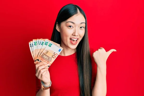 Mulher Chinesa Jovem Segurando Monte Notas Euro Apontando Polegar Até — Fotografia de Stock