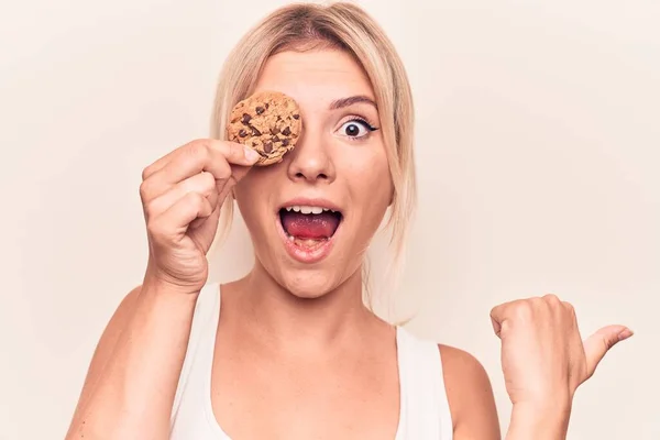 Junge Schöne Blonde Frau Hält Süßen Schokoladenkeks Über Dem Auge — Stockfoto