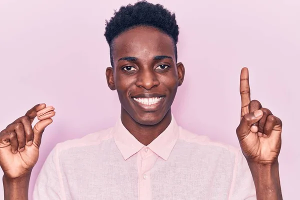若いアフリカ系アメリカ人の男は 幸せな顔をしたアイデアや質問を指差す指で笑顔を保持 ナンバーワン — ストック写真