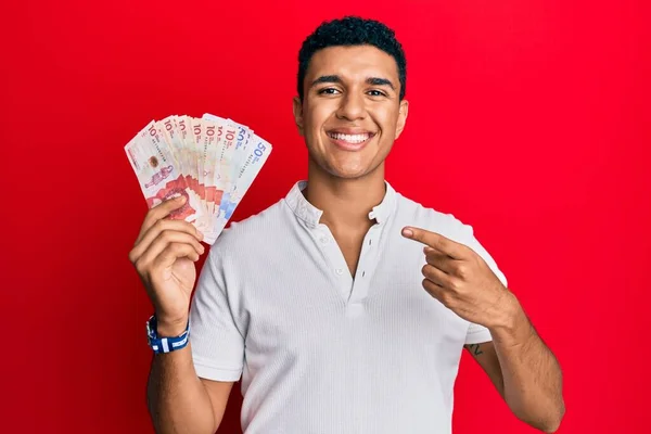 Joven Árabe Sosteniendo Pesos Colombianos Sonriendo Feliz Señalando Con Mano —  Fotos de Stock