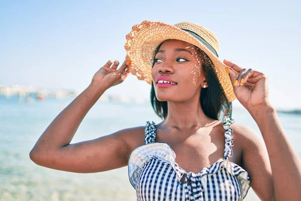 Young african american woman on vacation smiling happy walking at the beach