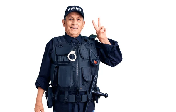 勝利サインをするカメラには幸せそうな顔で笑顔で警察制服を着たシニアハンサムな男 — ストック写真