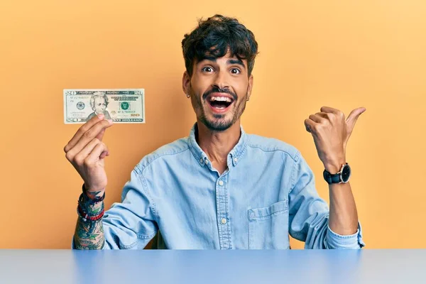 Fiatal Spanyol Férfi Kezében Dolláros Bankjegy Mutatva Hüvelykujját Oldalára Mosolyogva — Stock Fotó