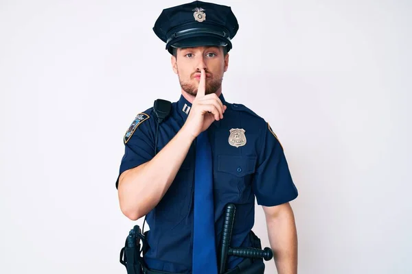 唇に指で静かにして欲しいと警察の制服を着た若い白人男性 沈黙と秘密の概念 — ストック写真