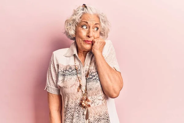 头发灰白的老年妇女穿着休闲装 看上去很紧张 双手放在咬指甲的嘴上 焦虑问题 — 图库照片