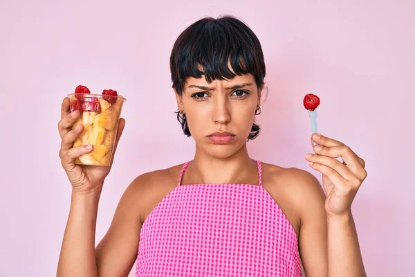 美しいブルネットの女性は 問題のために動揺を眉をひそめて 新鮮で健康的な果物懐疑的で神経を食べている 否定的な人 — ストック写真