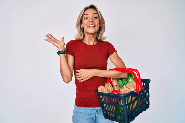 Beautiful Caucasian Woman Holding Supermarket Shopping Basket Celebrating Victory Happy — Stock Photo, Image