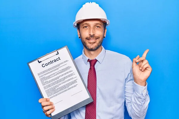 Jovem Homem Bonito Vestindo Arquiteto Hardhat Segurando Documento Contratual Sorrindo — Fotografia de Stock