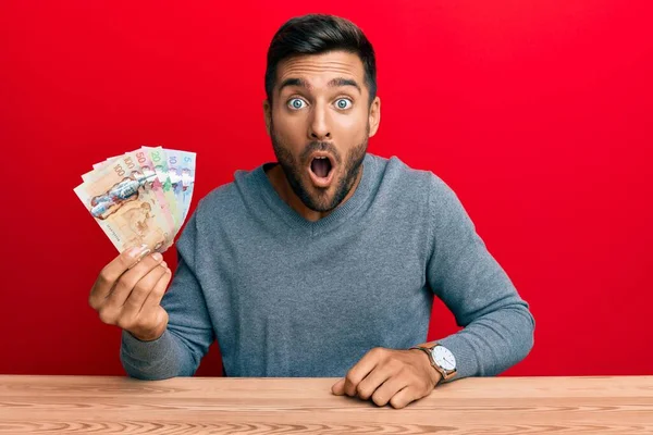 Bonito Hispânico Homem Segurando Dólares Canadenses Assustado Espantado Com Boca — Fotografia de Stock