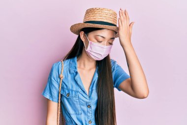Yazın tıbbi maske takan Çinli genç bir kadın, hata için elleri kafalarında şaşırdı. Hatayı unutmayın. Unuttum, kötü hafıza kavramı. 