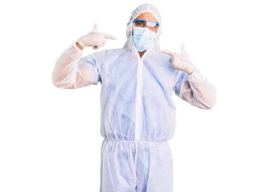 Koronavirüs üniforması giyen, gülümseyen, parmaklarını ve ağzını gösteren tıbbi maske takan İspanyol genç bir adam. diş sağlığı kavramı. 