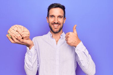 Genç yakışıklı adam hafızasını geri kazıyarak mutlu ve olumlu bir şekilde gülümseyen, mükemmel ve onay işareti yapan bir beyin istiyor.