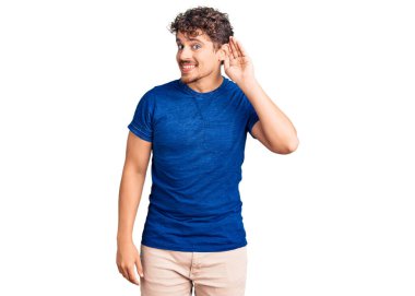 Kıvırcık saçlı, sıradan kıyafetler giyen, el pençe divan gülümseyen dedikoduları ve dedikoduları dinleyen genç yakışıklı bir adam. Sağırlık kavramı. 