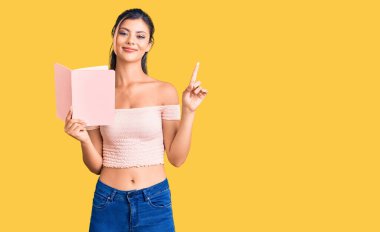 Elinde kitap tutan genç ve güzel bir kadın bir fikir ya da soruyla şaşırdı mutlu yüzle işaret etti, bir numara. 