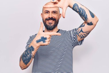 Gündelik kıyafetler giyen, gülümseyen, elleri ve parmakları gülen yüzlü genç yakışıklı bir adam. yaratıcılık ve fotoğrafçılık kavramı. 