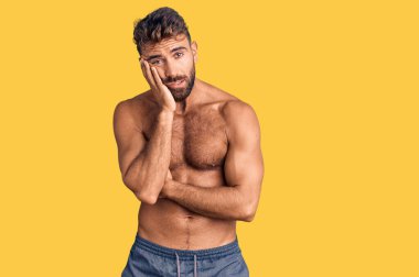 Mayo giyen genç İspanyol adam kollarını kavuşturarak depresyondan sıkılmış ve yorgun görünüyor.. 