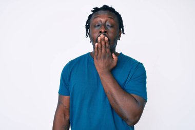 Saçları günlük giysiler giyen Afro-Amerikan genç adam ağzıyla esnemekten sıkılmış. Huzursuz ve uykulu.. 