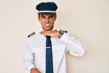 Uçak pilotu üniforması giyen genç İspanyol bir adam bıçakla boğazını kesiyor, saldırganlığı şiddetli bir şiddetle tehdit ediyor. 