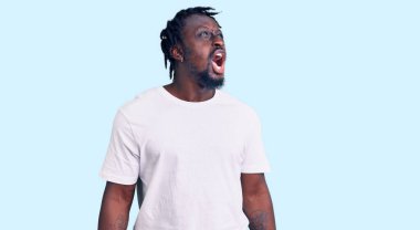 Örgülü beyaz tişörtlü, öfkeli ve kızgın bağıran öfkeli öfkeli, öfkeyle bağıran Afro-Amerikalı genç bir adam. öfke ve agresif konsept. 