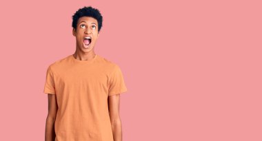 Genç, Afro-Amerikan bir adam, günlük giysiler giymiş kızgın ve kızgın bağırıyor, sinirlenmiş ve öfkeyle bağırıyor. öfke ve agresif konsept. 