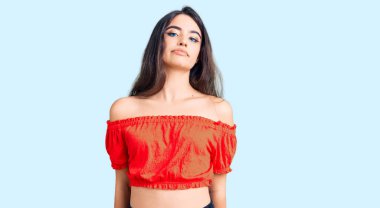 Esmer, sıradan kıyafetler giyen genç bir kız. Yüzünde ciddi bir ifadeyle rahatlamış. Basit ve doğal bir şekilde kameraya bakıyorsun.. 