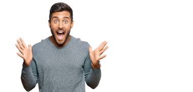 Yakışıklı İspanyol bir adam sıradan kıyafetler giyip çılgınlığı kutluyor ve başarıya hayret ediyor kolları açık ve gözleri açık heyecanla bağırıyor. Kazanan konsept 