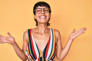 Güzel esmer kadın, sıradan kıyafetler ve gözlük takıp başarının çılgınlığını kutluyor. Kolları havada ve gözleri kapalı, heyecanla bağırıyor. Kazanan konsept 